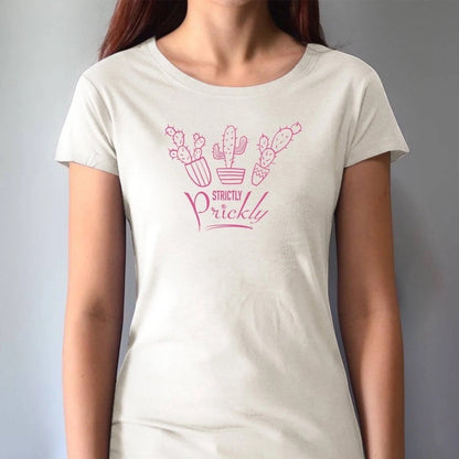 Model wearing cream cactus t-shirt for women with pink 'Strictly Prickly' print. Organic cotton and bamboo blend for eco-conscious style.