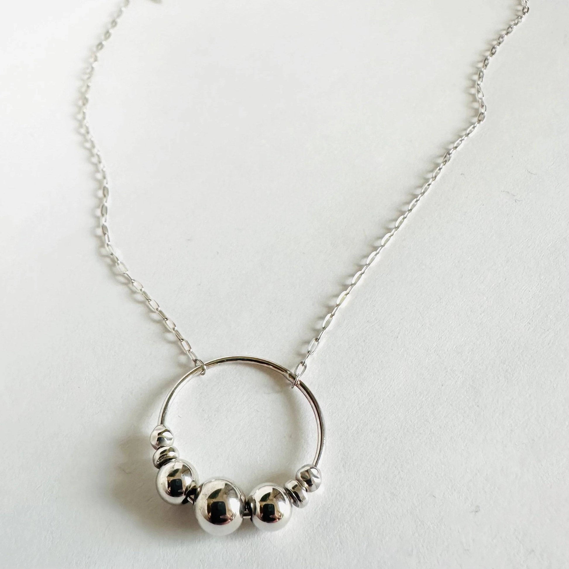 Minimalist Silver Circle Necklace with sterling beads on a round pendant. A chic fidget accessory and meaningful family necklace.