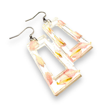 Rectangular open-frame resin earrings with pink petals. Silver hooks enhance the modern floral design from Real Flower Earrings.