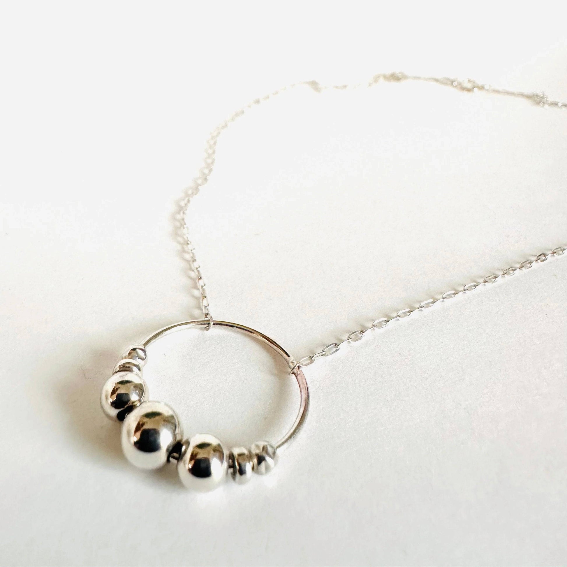 Silver Circle Necklace with spinning sterling beads on an 18” chain. A stylish fidget accessory ideal for daily wear or gifting.