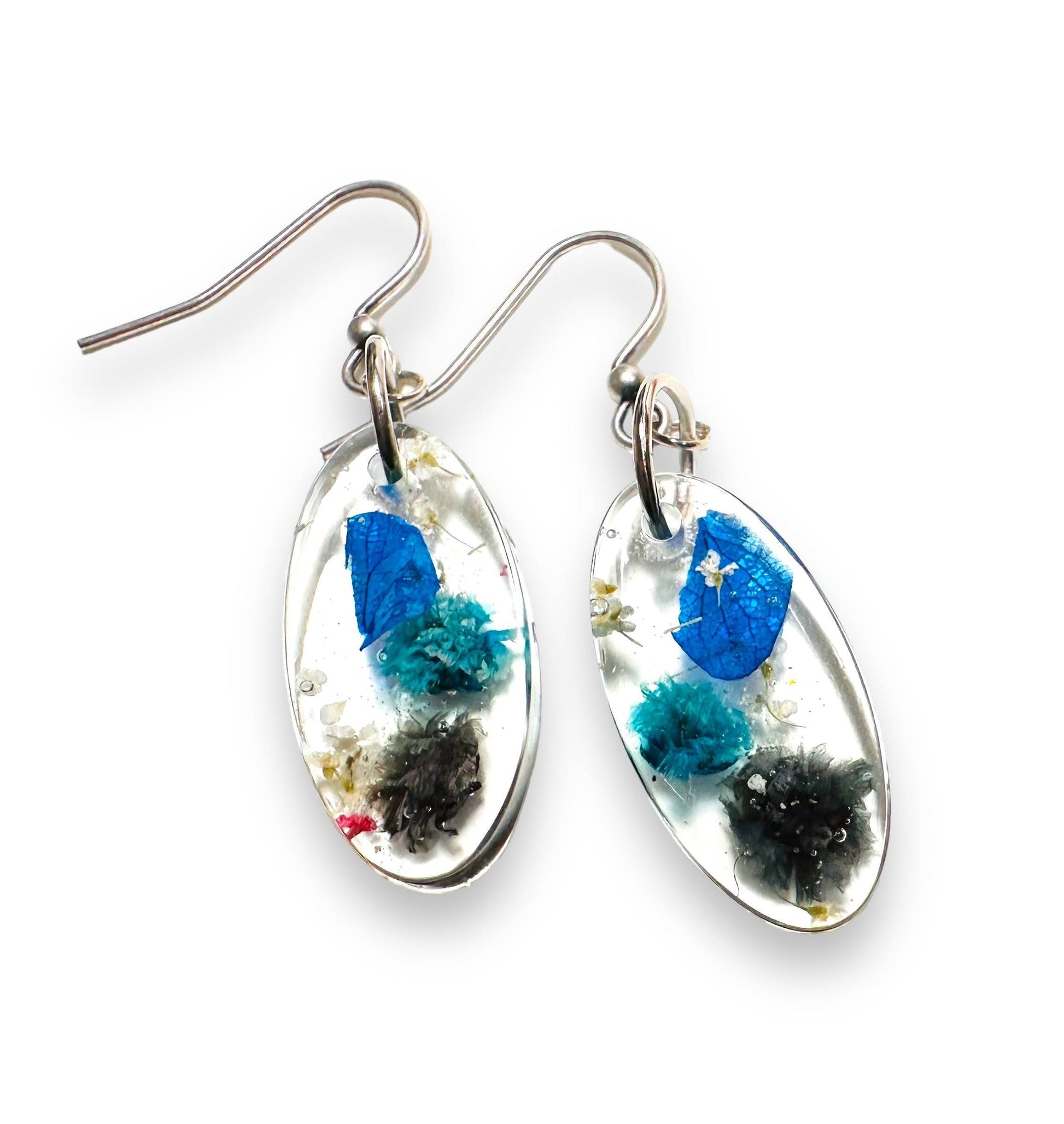 Small oval resin earrings with electric blue and black flowers. Features silver hooks from the Real Flower Earrings collection.