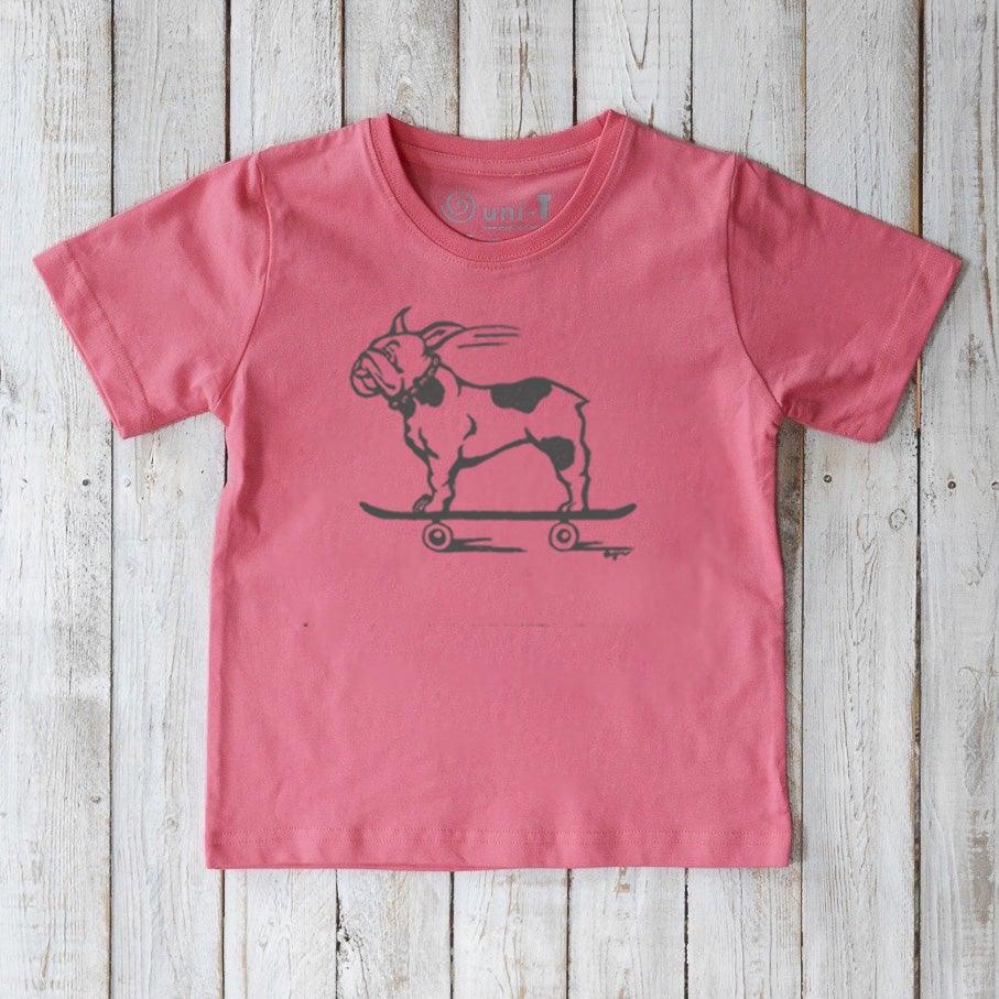 Coral pink kids’ t-shirt made from organic cotton, featuring a black skateboarding French Bulldog. Eco-friendly Uni-T graphic tee.