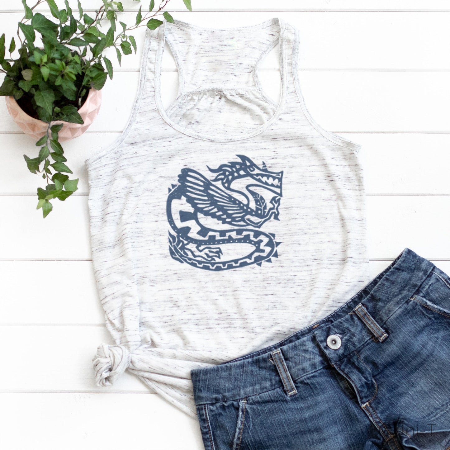 White racerback dragon tank top for women featuring a bold mythical dragon design, styled with denim shorts for a casual look.