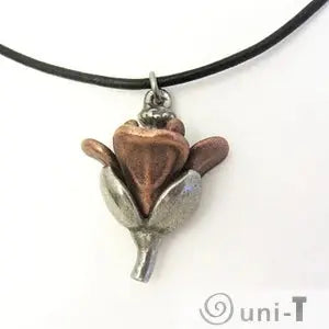 Back view of Arabidopsis Flower Necklace - Elegant Garden Charm highlighting the sculpted floral form in bronze and silver finish on a leather cord.