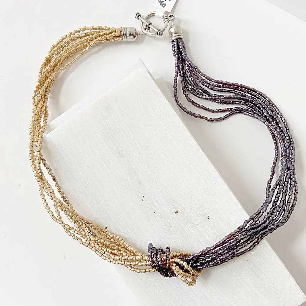 Beaded Two Tone Knot Necklace with golden and metallic burgundy strands, featuring a central knot design. Elegant 18-inch blue metallic necklace.