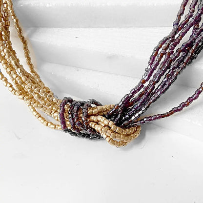 Close-up of Beaded Two Tone Knot Necklace showing intricate knot detail with golden and burgundy beads. Stylish accessory for modern outfits.