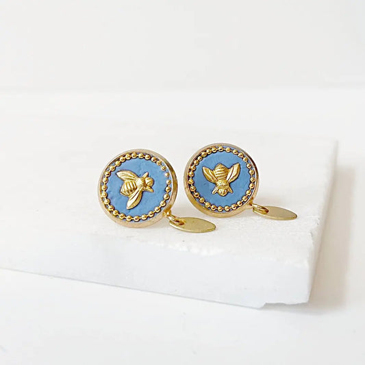 Bee stud earrings with brass posts and blue crystal background, featuring gold bee design and beaded trim, perfect for stylish accessorizing.