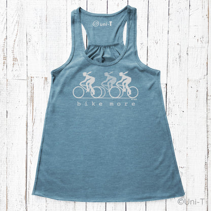 Teal blue racerback flowy tank top for women featuring eco-friendly 'bike more' cycling design, perfect for casual or athletic wear.