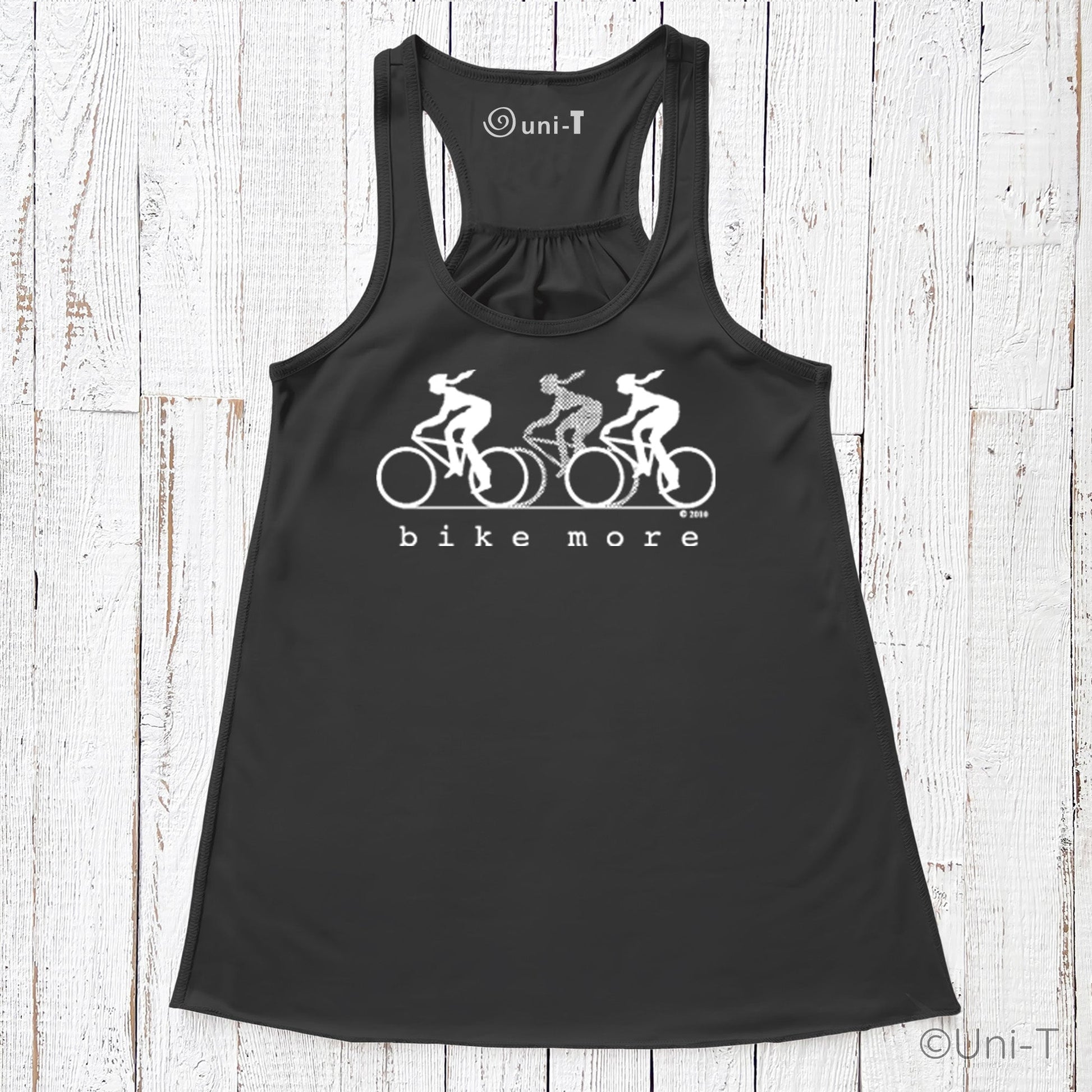 Black racerback flowy tank top for women with white 'bike more' cycling graphic, promoting sustainable living and active fashion.