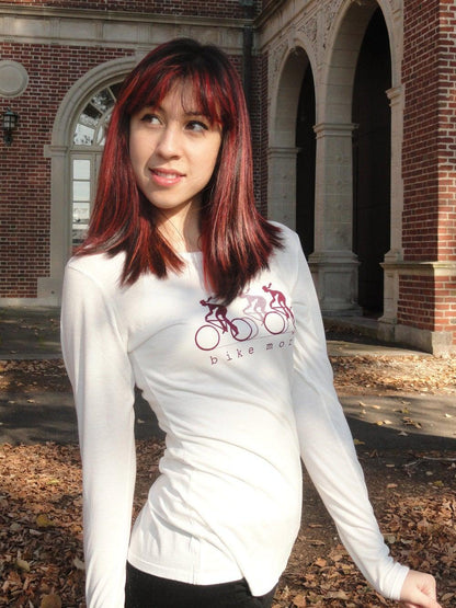Model wearing cream 'Bike More' Women's Bicycle Long Sleeve T-Shirt made from bamboo and organic cotton, styled for autumn cycling.