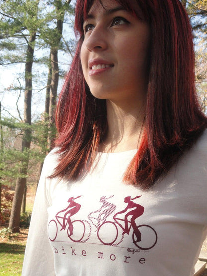 Close-up of model in cream bamboo and organic cotton Women's Bicycle Long Sleeve T-Shirt with maroon 'Bike More' cycling graphic.