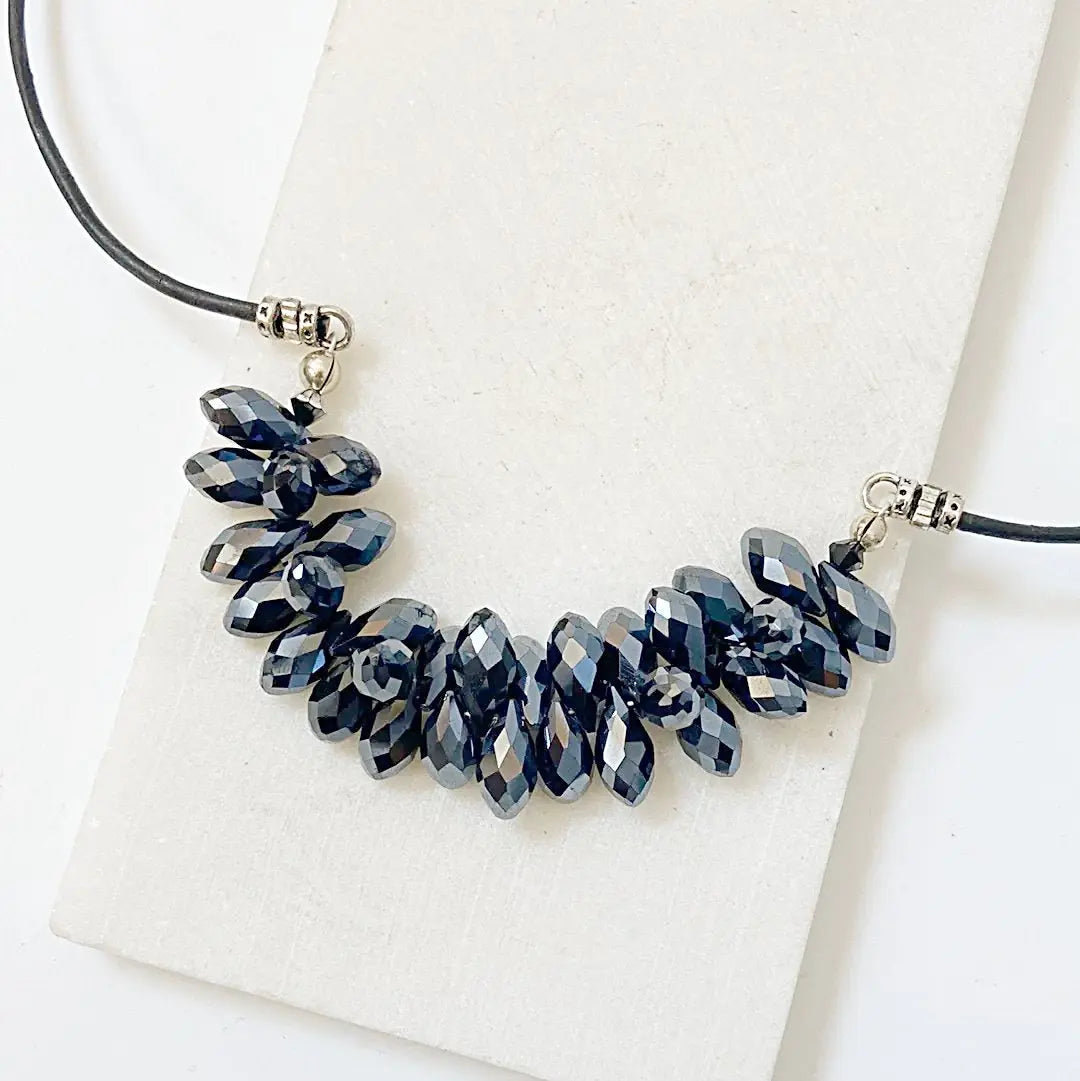 Close-up of the Black Crystal Necklace with clustered faceted black crystals on a 19” leather cord, ideal for gothic or boho styles.