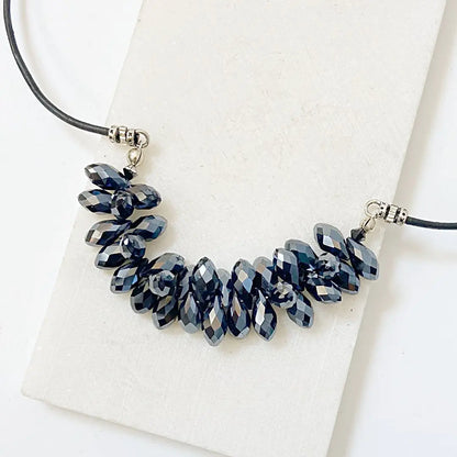 Close-up of the Black Crystal Necklace with clustered faceted black crystals on a 19” leather cord, ideal for gothic or boho styles.