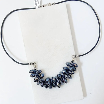 Full view of the Black Crystal Necklace with hematite-toned crystals on a black leather cord, part of the Black Crystal Jewelry Set.
