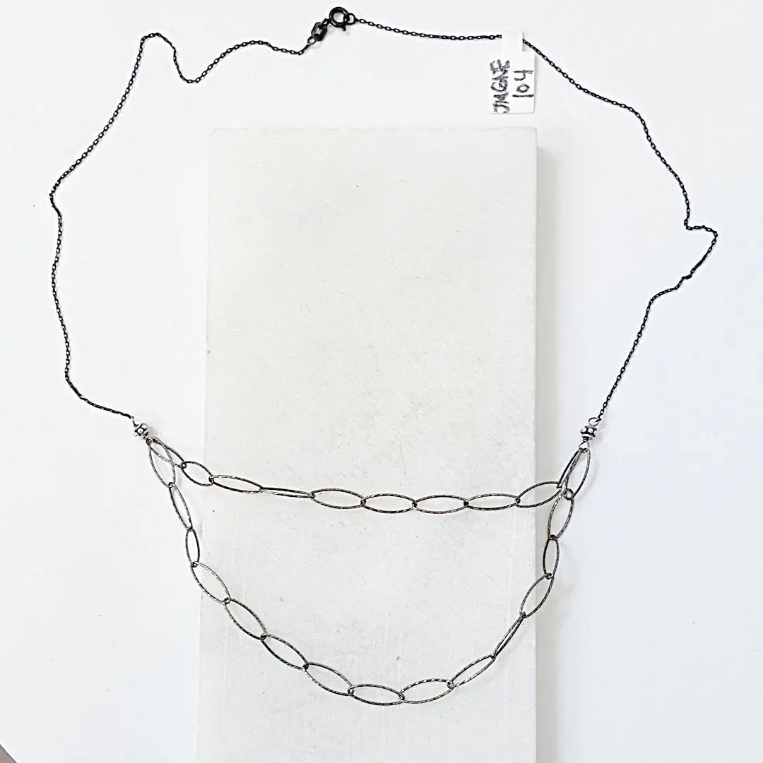 Blackened oval sparkle chain necklace with silver Bali beads, featuring a double-layered design for edgy, wire-wrapped layering style.
