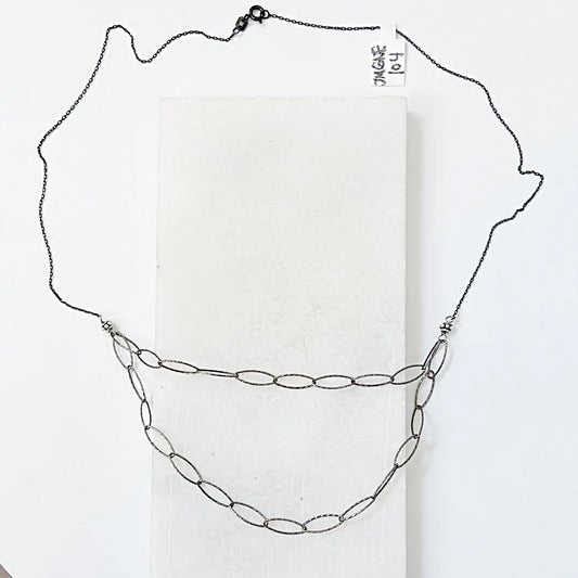 Blackened oval sparkle chain necklace with silver Bali beads, featuring a double-layered design for edgy, wire-wrapped layering style.
