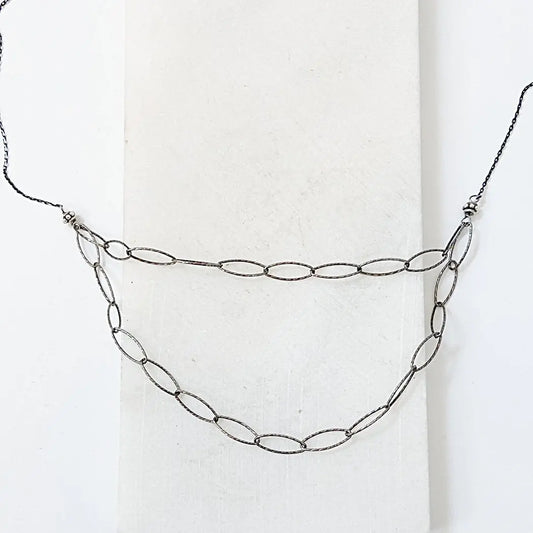 Silver blackened oval chain necklace with two-tiered sparkle links, ideal for layering and adding a bold, modern touch to any outfit.