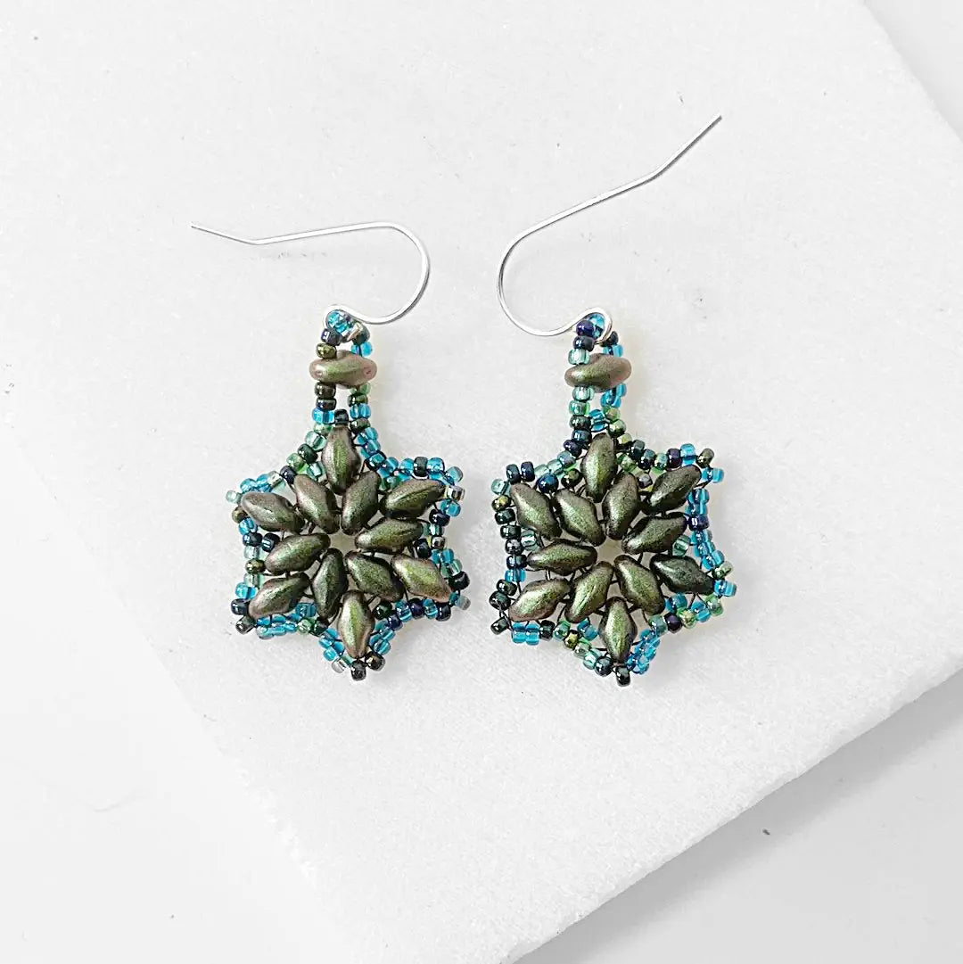Sterling silver flower medallion earrings with frosted green petals and blue glass beads. Elegant floral jewelry for accessory lovers.