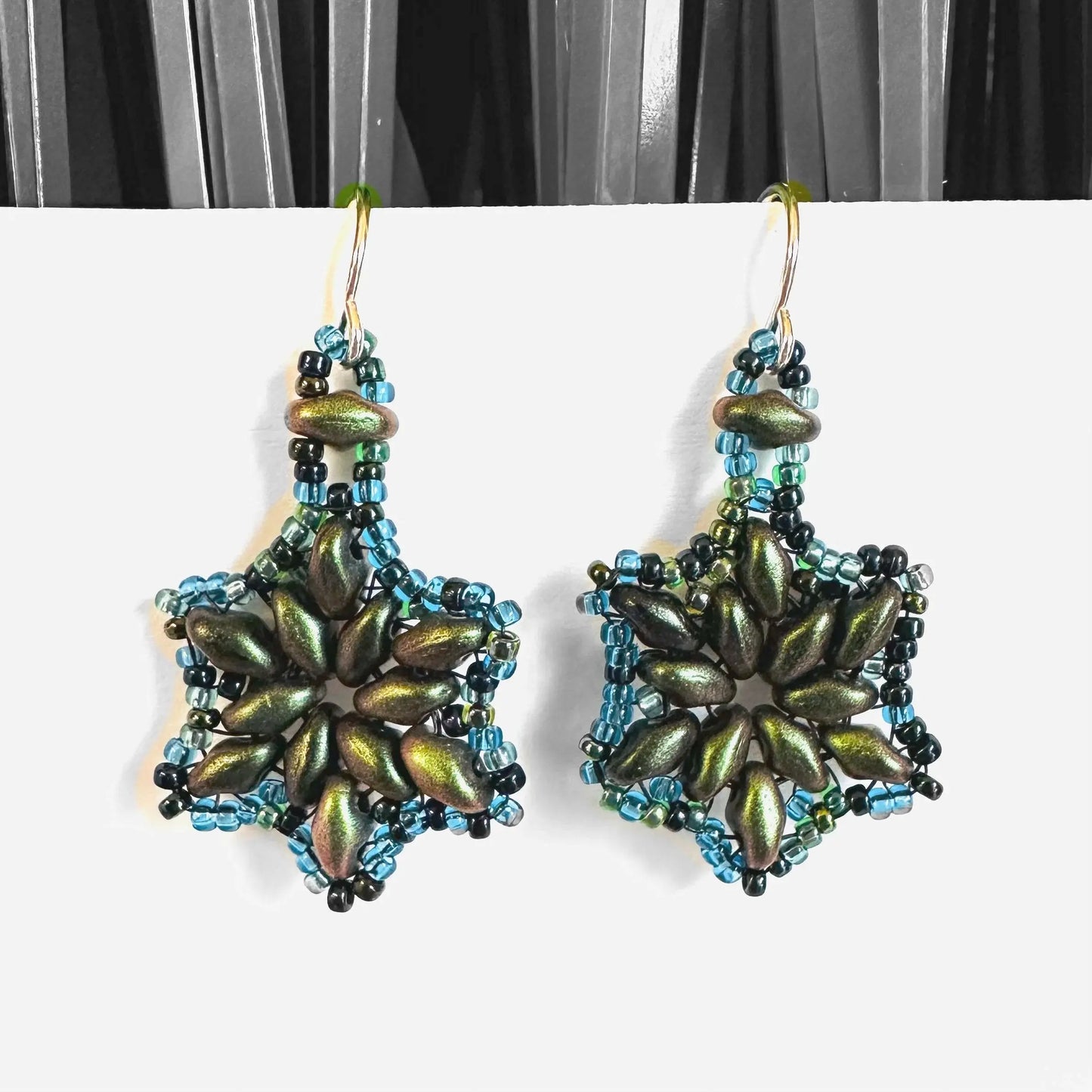 Metallic green flower medallion earrings with blue beaded accents and silver hooks. Unique floral earrings for stylish gifting.