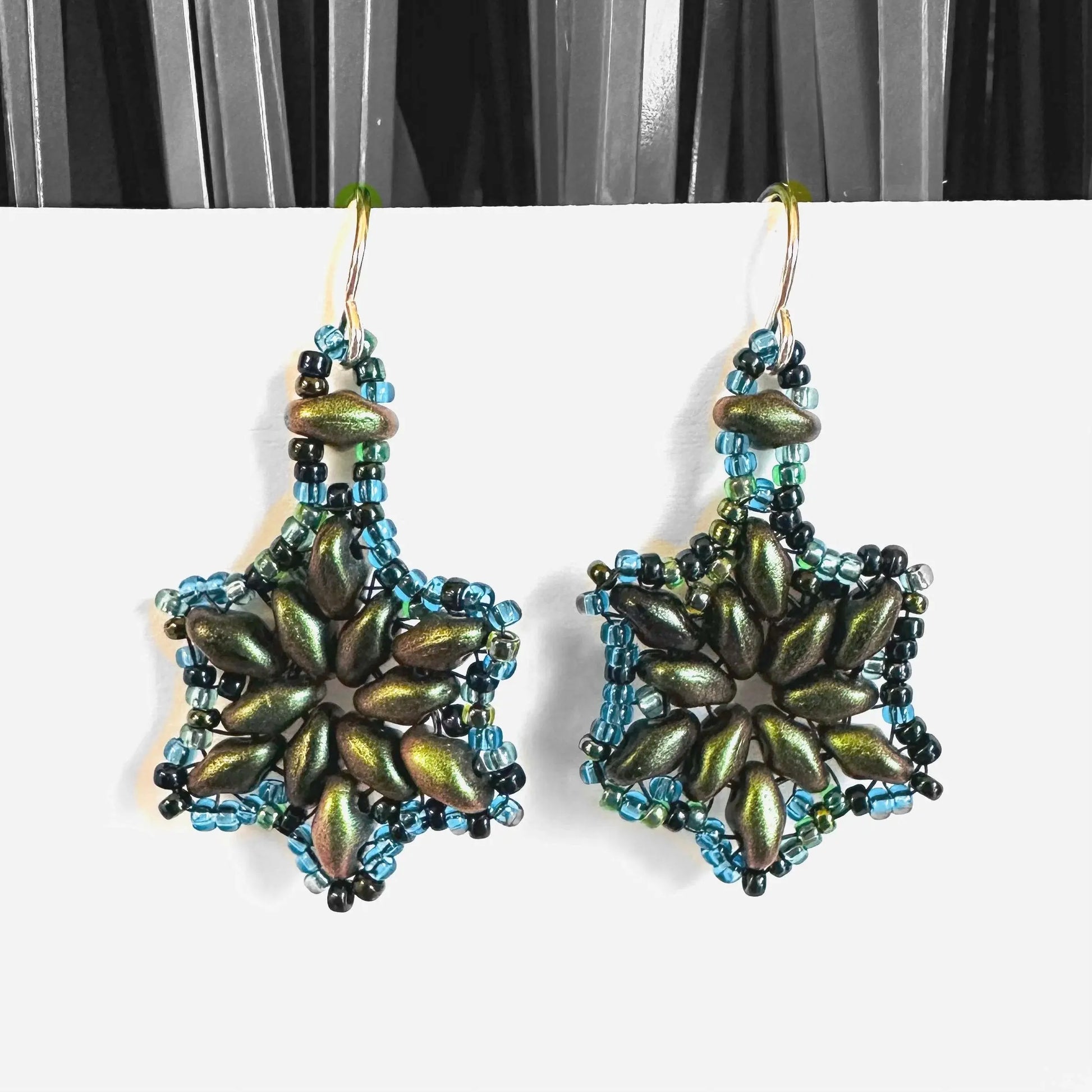 Metallic green flower medallion earrings with blue beaded accents and silver hooks. Unique floral earrings for stylish gifting.