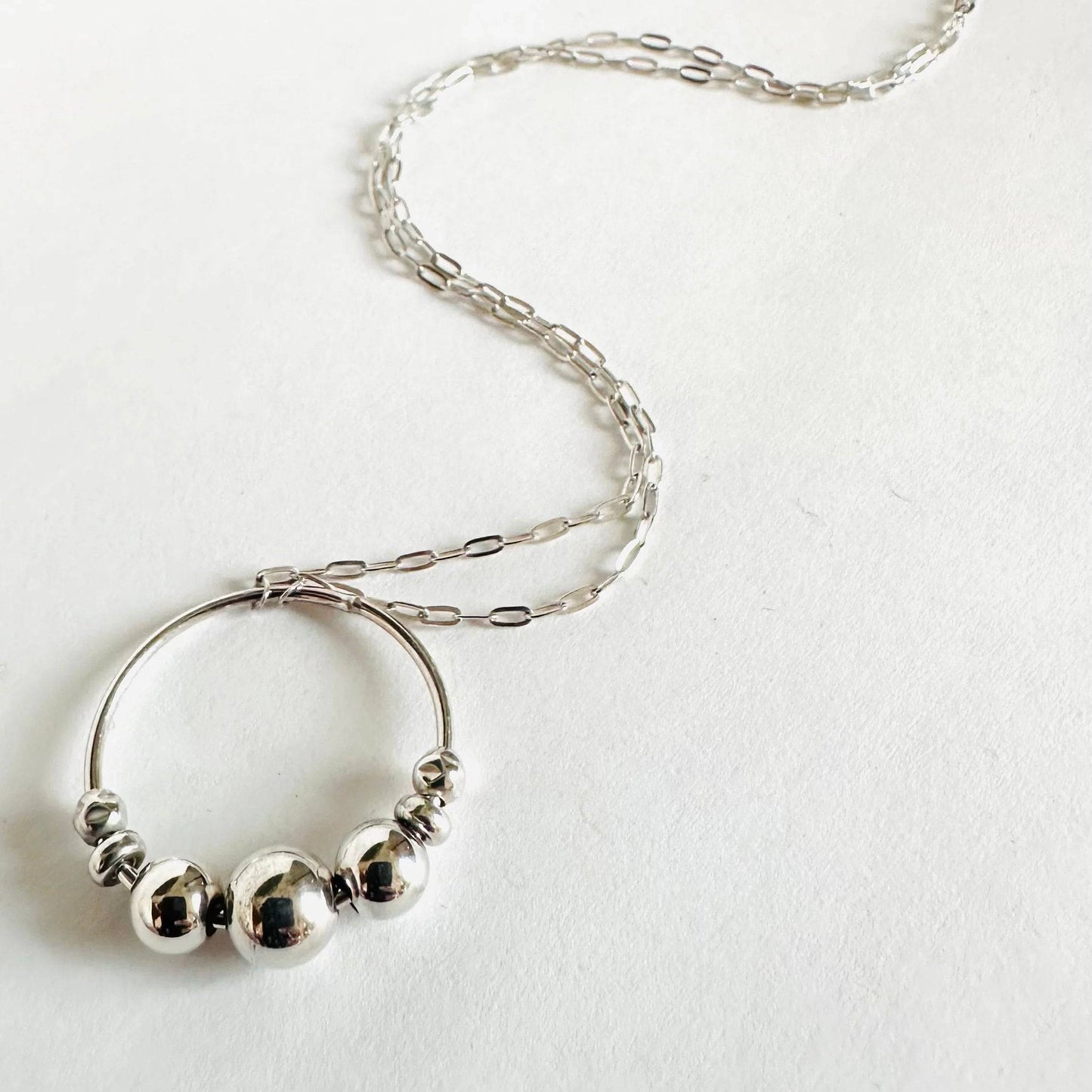 Sterling Silver Circle Necklace with smooth spinning beads on a fine chain. A fashionable and functional fidget jewelry piece.