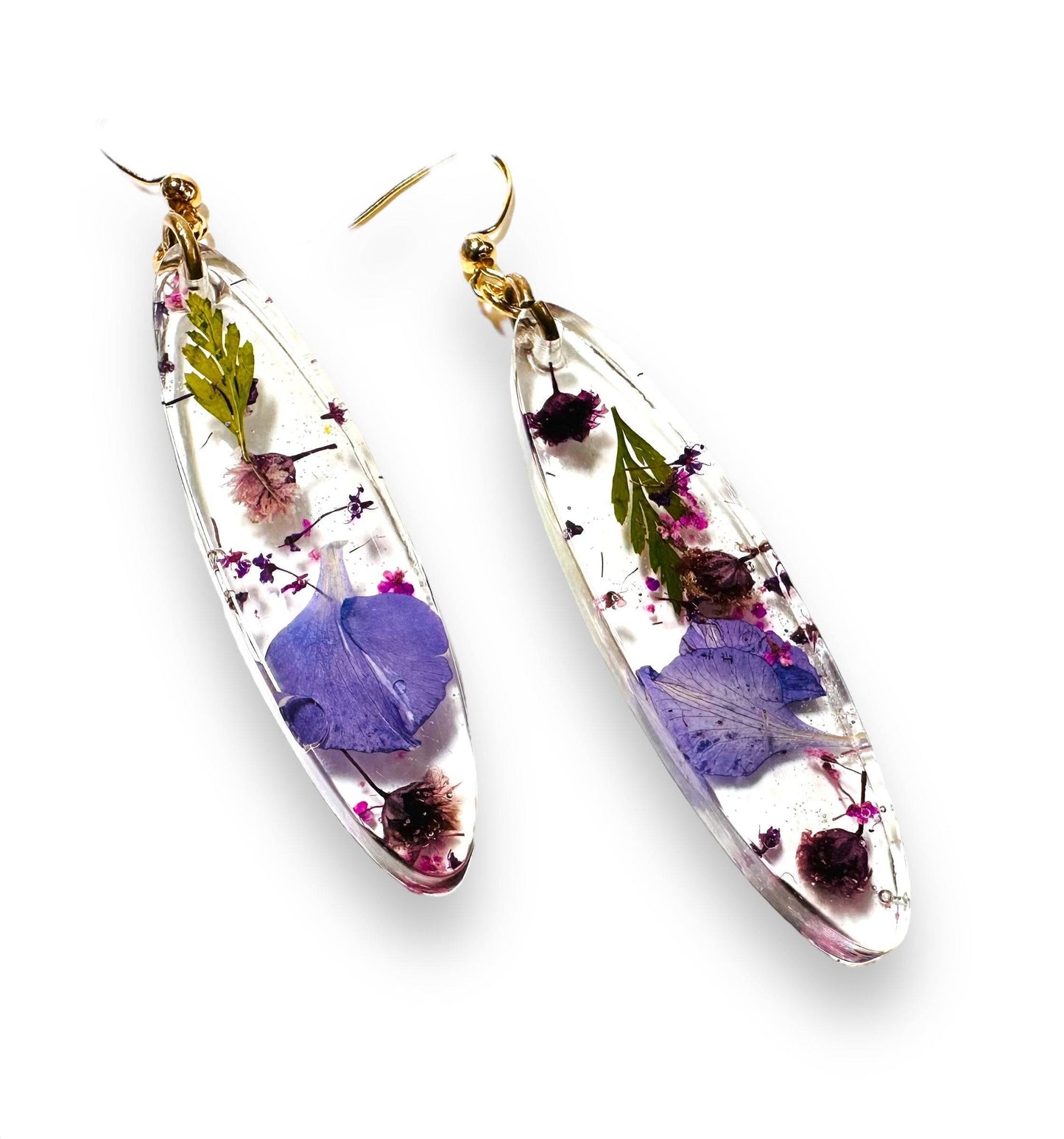 Pressed Flower Earrings featuring purple and green real flowers in resin. Gold hooks add elegance to this natural jewelry piece.