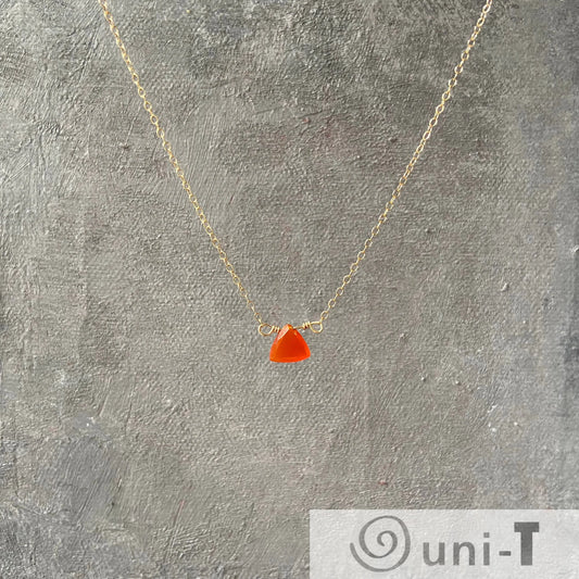 Buy Carnelian Gemstone Necklaces Online - Uni-T gold-filled chain with triangular red gemstone pendant displayed on textured gray background.
