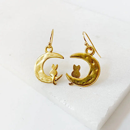 Gold plated cat earrings featuring a cat sitting on a crescent moon. Cat and Moon Earrings ideal for celestial and cat lovers.