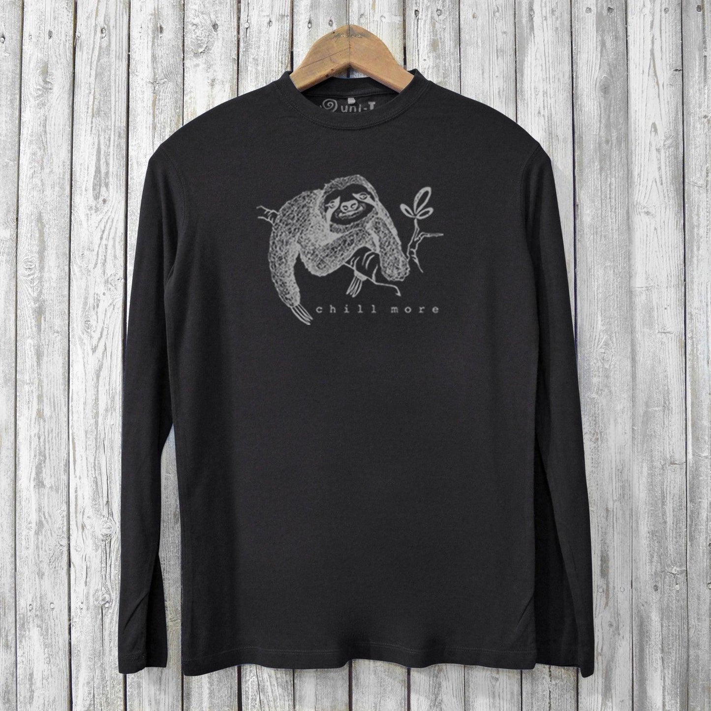 Black eco-friendly men's long sleeve shirt with sloth illustration and 'Chill More' slogan, made from bamboo and organic cotton for comfort.