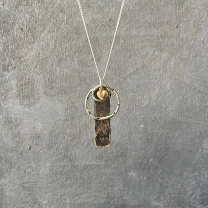 Handcrafted Circle Tag Necklace with hammered silver bar, gold heart charm, and silver ring on sterling chain. Unique artisan necklace.
