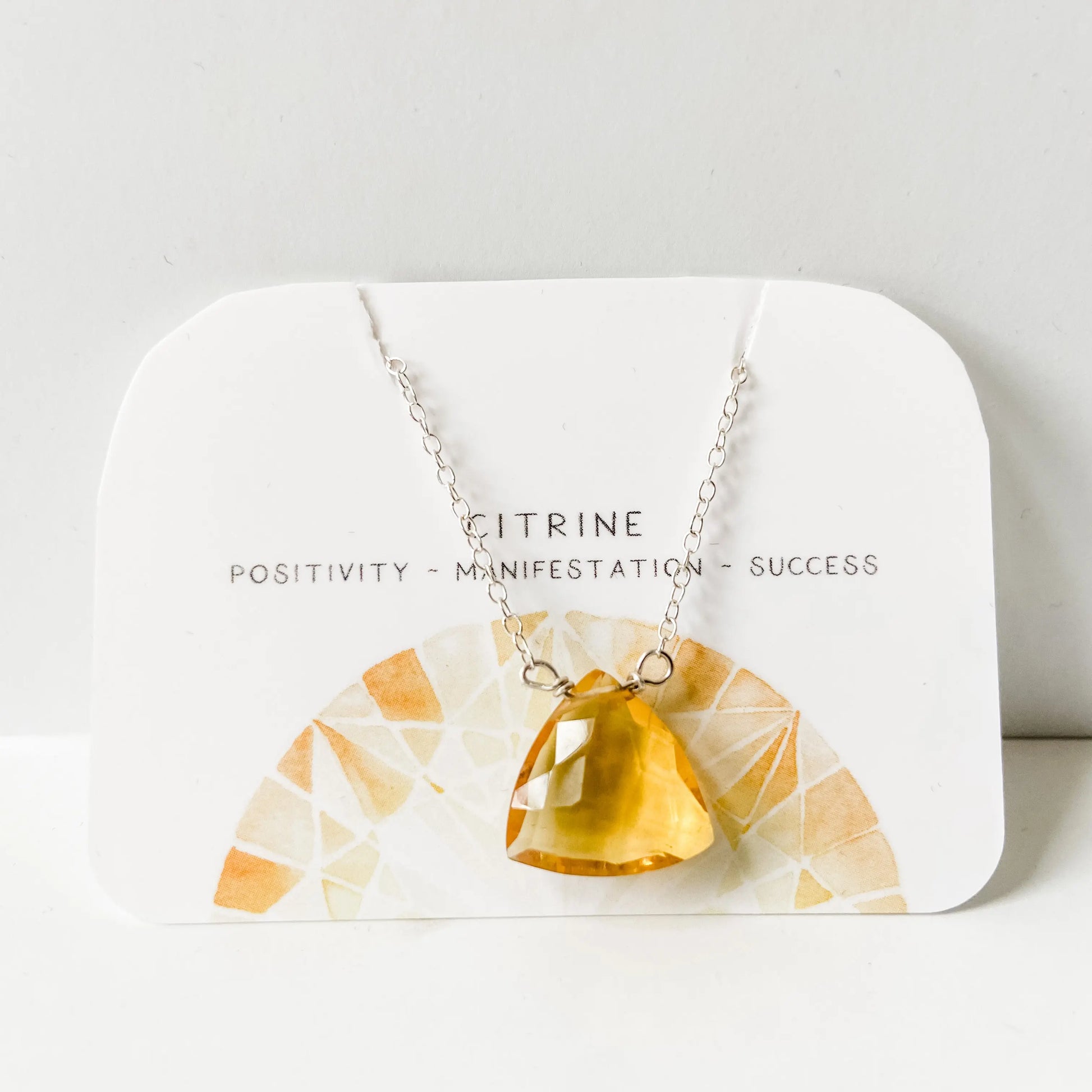Citrine Gemstone Necklace displayed on card with meanings: positivity, manifestation, success; features hand-cut citrine on silver chain.