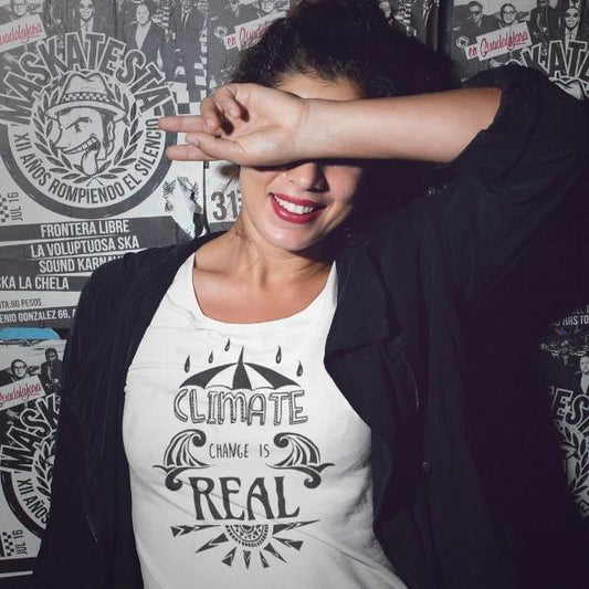 Woman wearing Women's Climate Change T-Shirt in Bamboo & Organic Cotton with 'Climate Change is Real' graphic, styled for activist fashion.