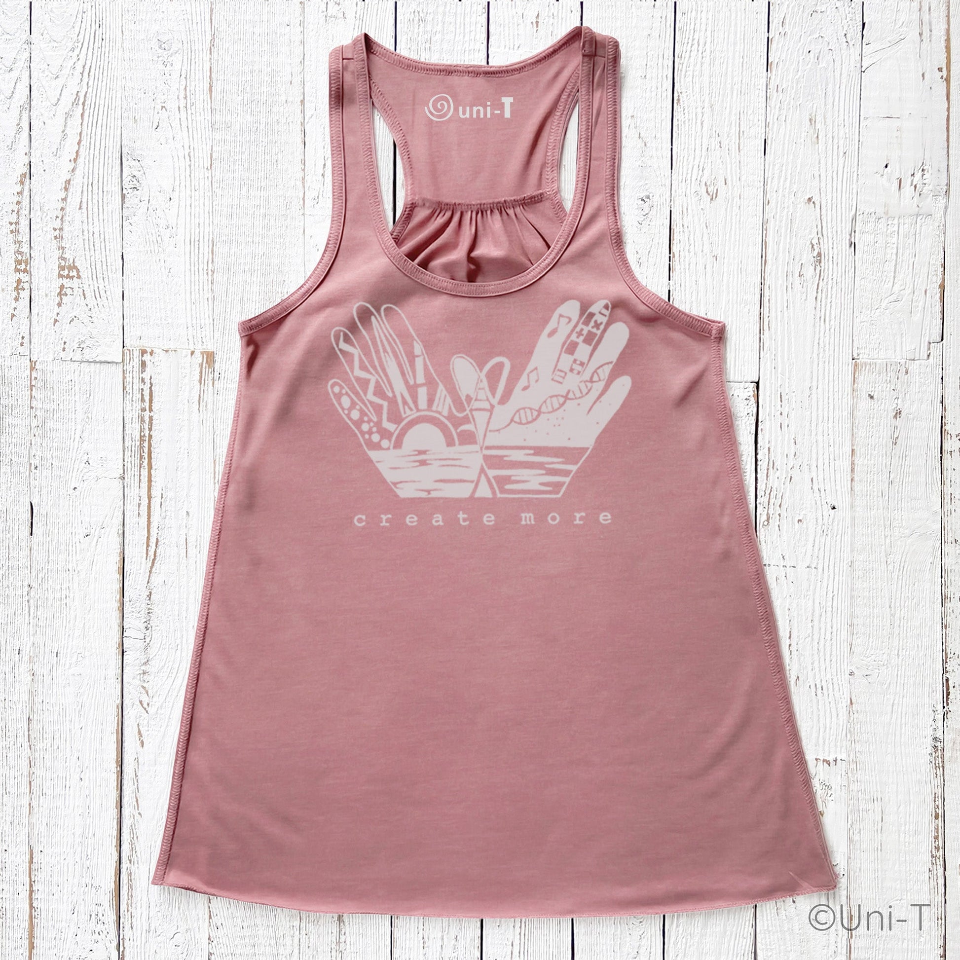 Rose pink 'Create More' flowy tank top for women with white hand illustration and nature elements. Ideal for artists and innovators.