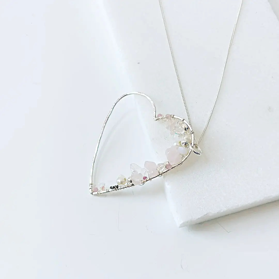 Sterling silver heart-shaped necklace featuring delicate crystals and pearls. Unique silver gemstone jewelry gift for her.