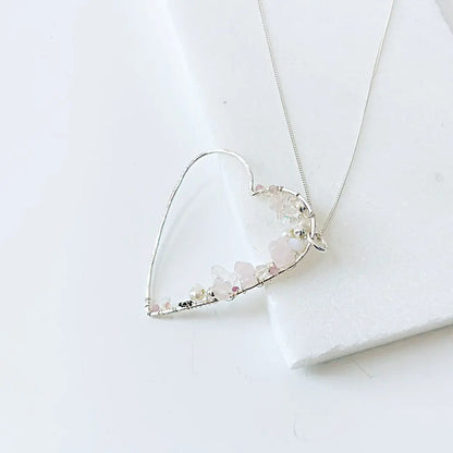 Sterling silver heart-shaped necklace featuring delicate crystals and pearls. Unique silver gemstone jewelry gift for her.