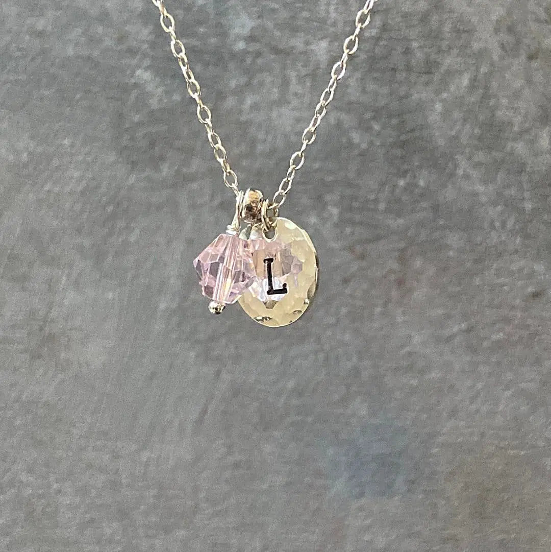 Personalized Initial Necklace featuring silver chain, pink crystal charm, and hammered disc with letter 'L'. Ideal custom gift accessory.