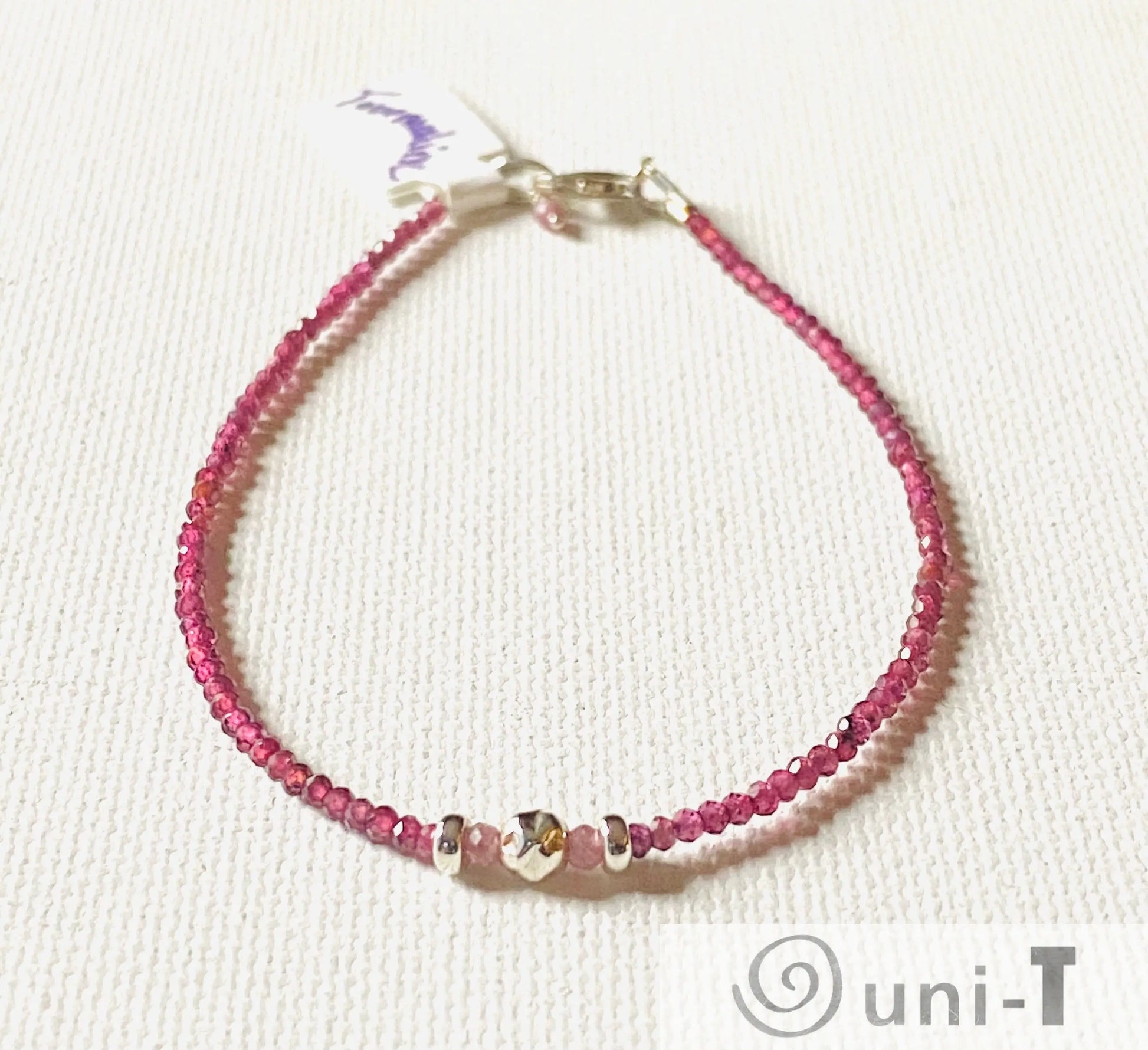 Dainty gemstone bracelet with faceted watermelon tourmaline beads and silver accents, featuring a secure clasp and minimalist design.
