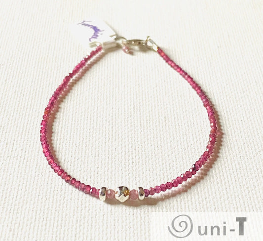 Dainty gemstone bracelet with faceted watermelon tourmaline beads and silver accents, featuring a secure clasp and minimalist design.