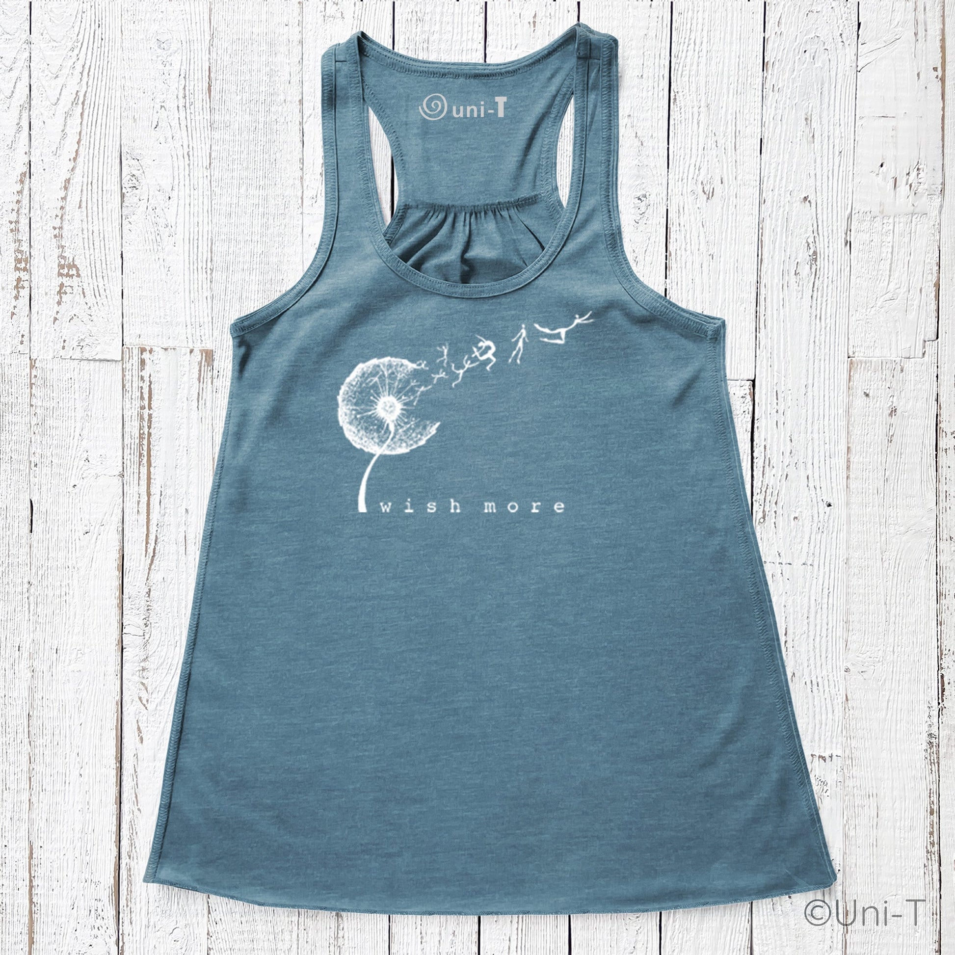 Wish More Flowy Tank in teal blue with white dandelion and flying figures design. Eco-friendly racerback top for women, soft and breathable.