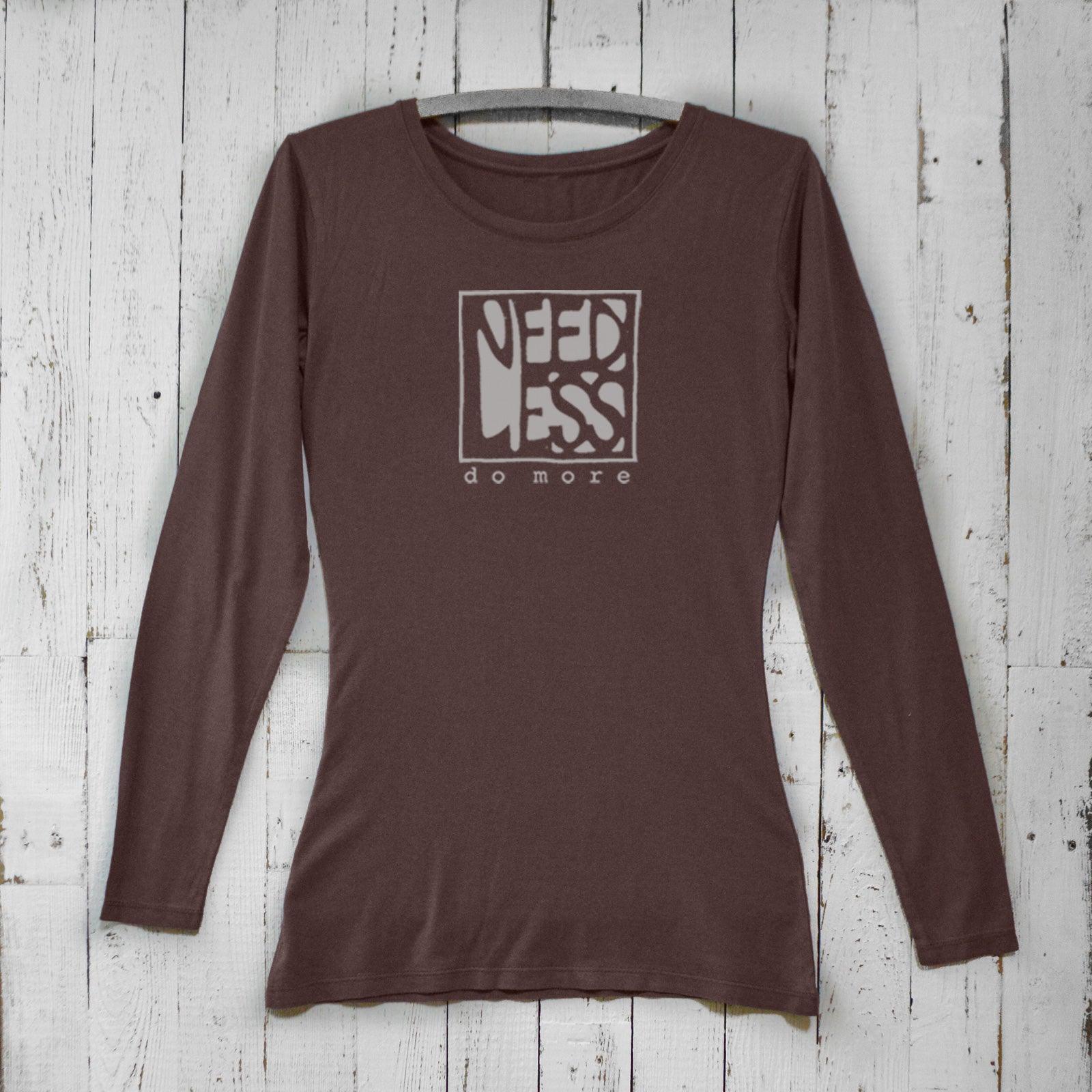 Dark brown women's long sleeve graphic tee made from bamboo and organic cotton. Features 'Need Less Do More' quote for intentional living.