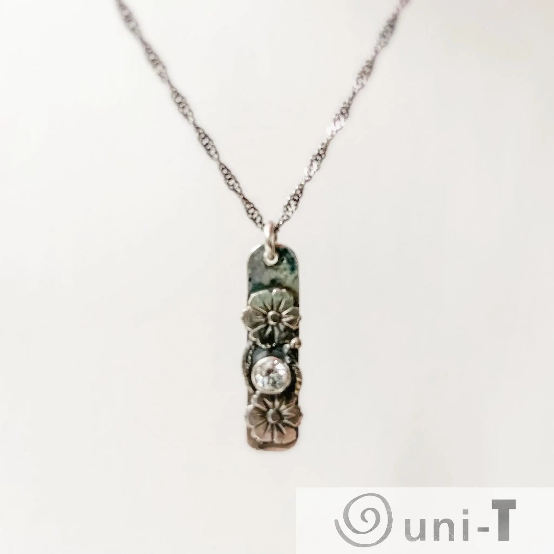 Flower Tag Necklace with cubic zirconia on sterling silver chain, featuring floral accents and antiqued rope chain for elegant sparkle.