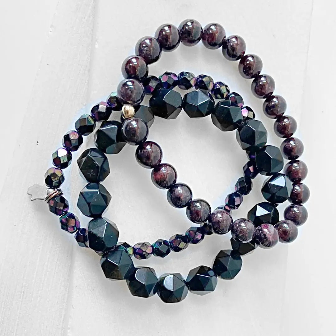 Top view of Garnet Black Obsidian Bracelet stack showcasing round garnet and faceted black obsidian beads in layered design.