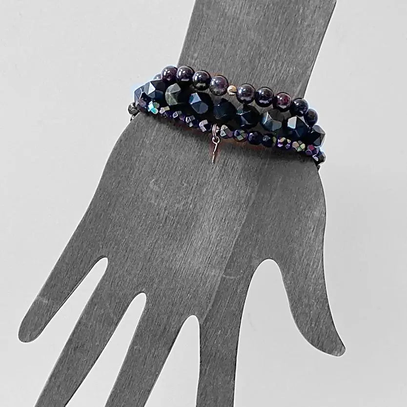 Garnet Black Obsidian Bracelet stack displayed on wrist silhouette, highlighting elegant triple stretch fit and bead detailing.
