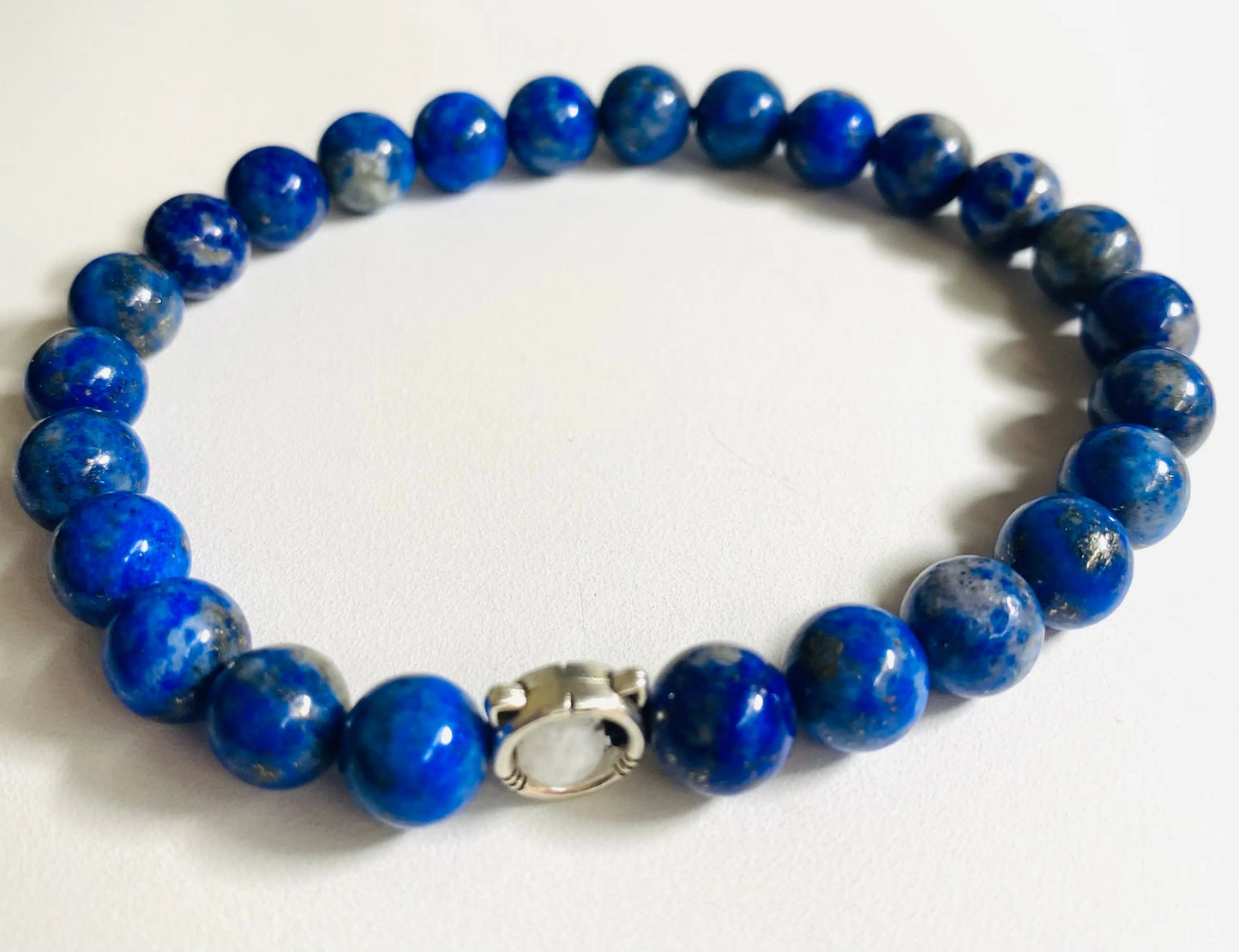 Lapis lazuli gemstone stretch bracelet with sterling silver clasp, showcasing deep blue tones for a bold fashion accessory.