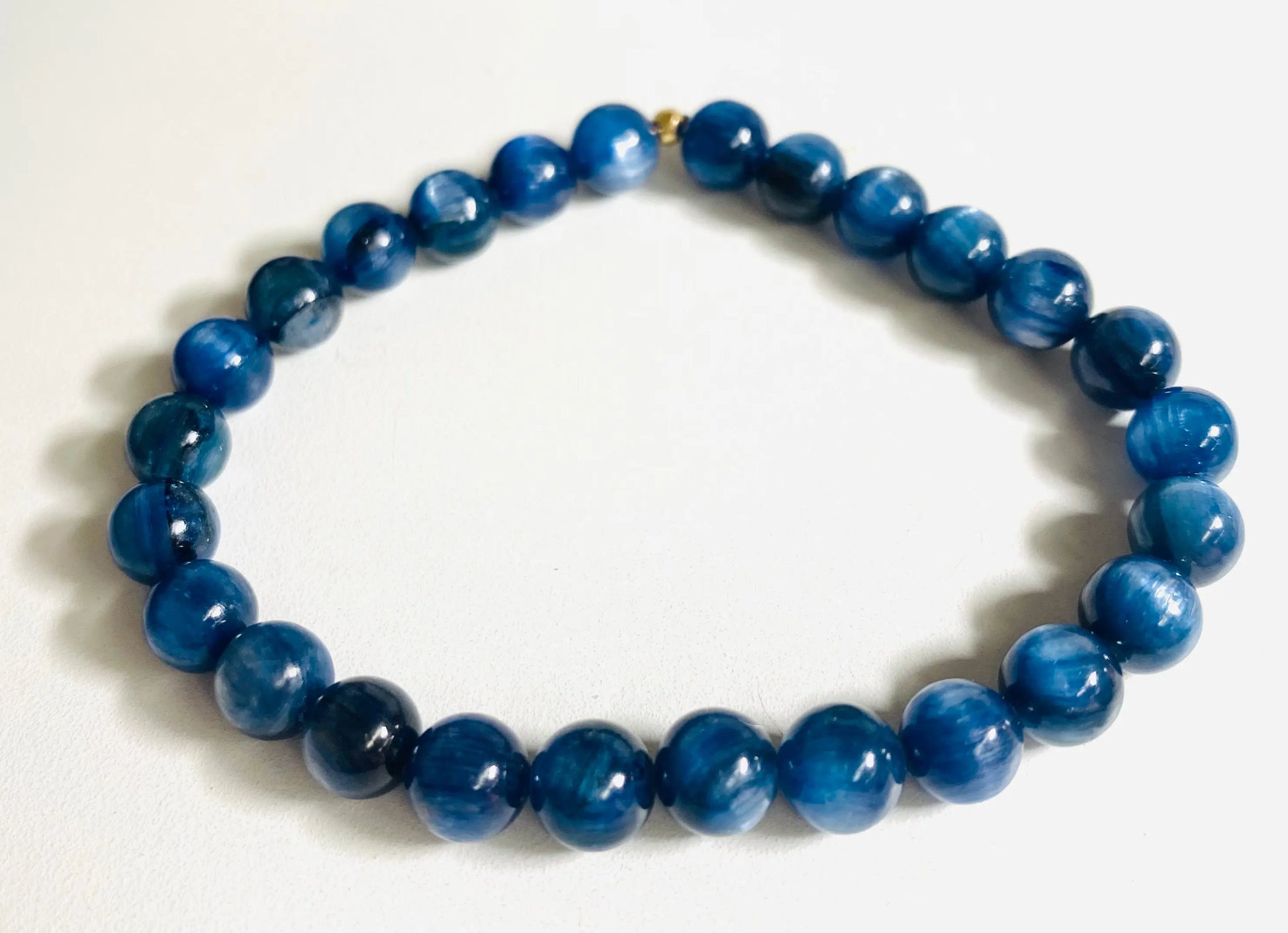 Blue kyanite gemstone stretch bracelet with polished round beads, ideal for calming energy and stylish wear.