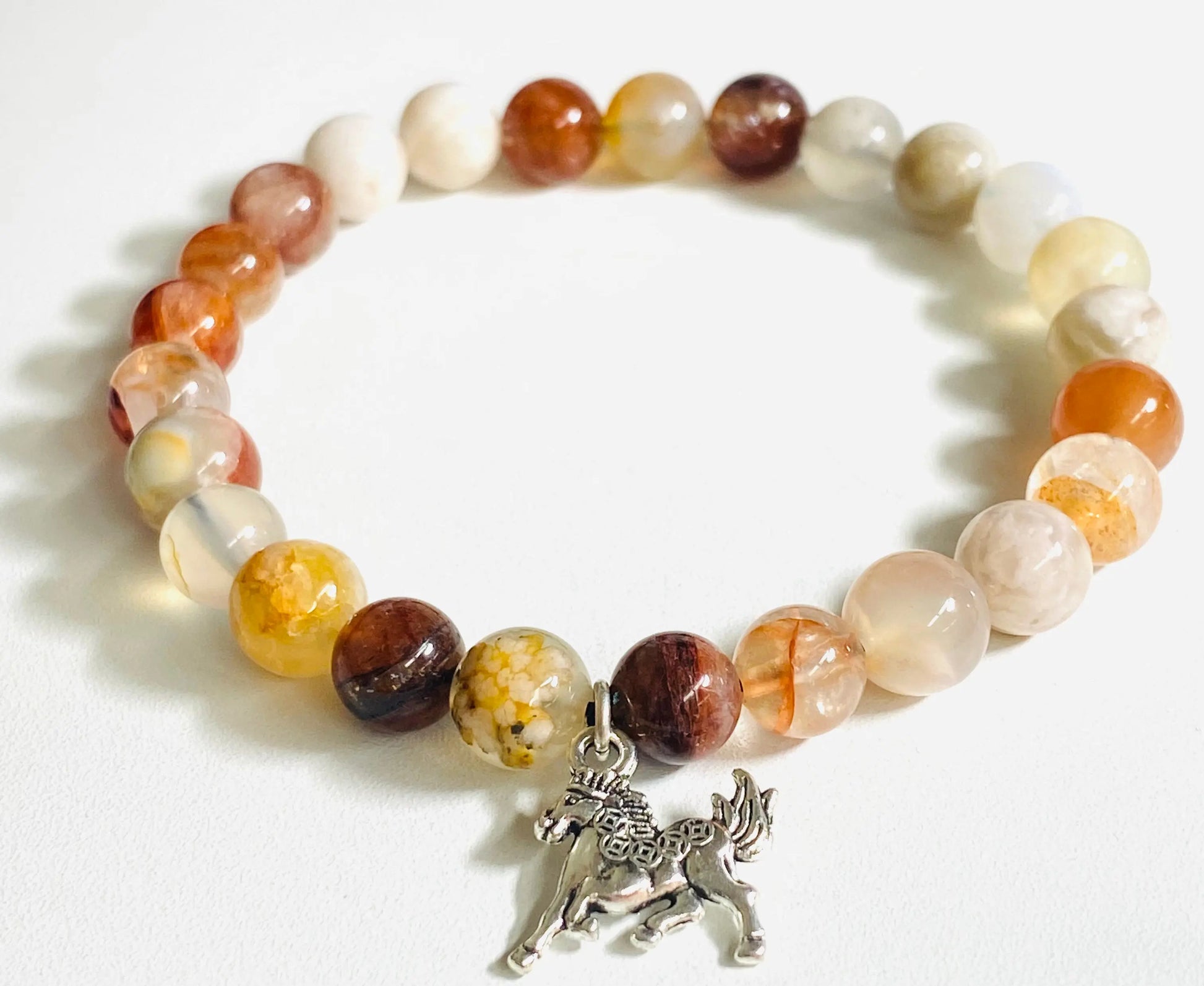 Mixed gemstone stretch bracelet with orange and white beads and a silver dog charm, perfect for unique jewelry lovers.