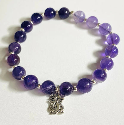 Amethyst gemstone stretch bracelet with silver dragon charm, ideal for spiritual healing and stylish expression.