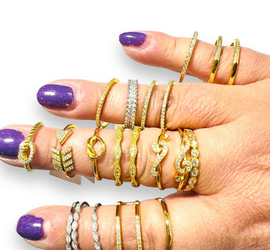 Gold filled stacking rings with cubic zirconias on fingers, showcasing dainty golden ring designs perfect for layering and accessorizing.