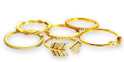 Set of six gold filled stacking rings with cubic zirconias, featuring arrow and wave designs for elegant and versatile styling.