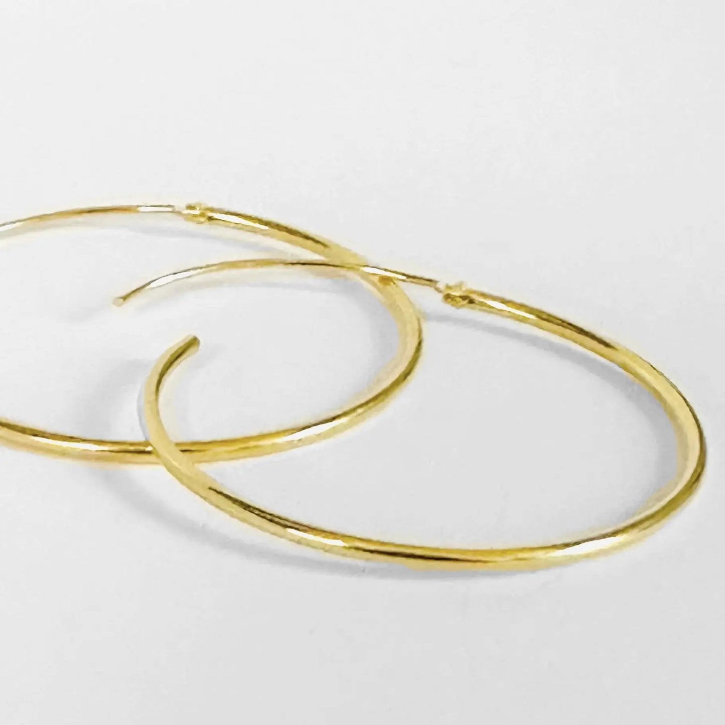 Gold filled hoops with a lightweight 1-inch design and hinge clasp, offering a sleek endless hoop look for everyday wear.
